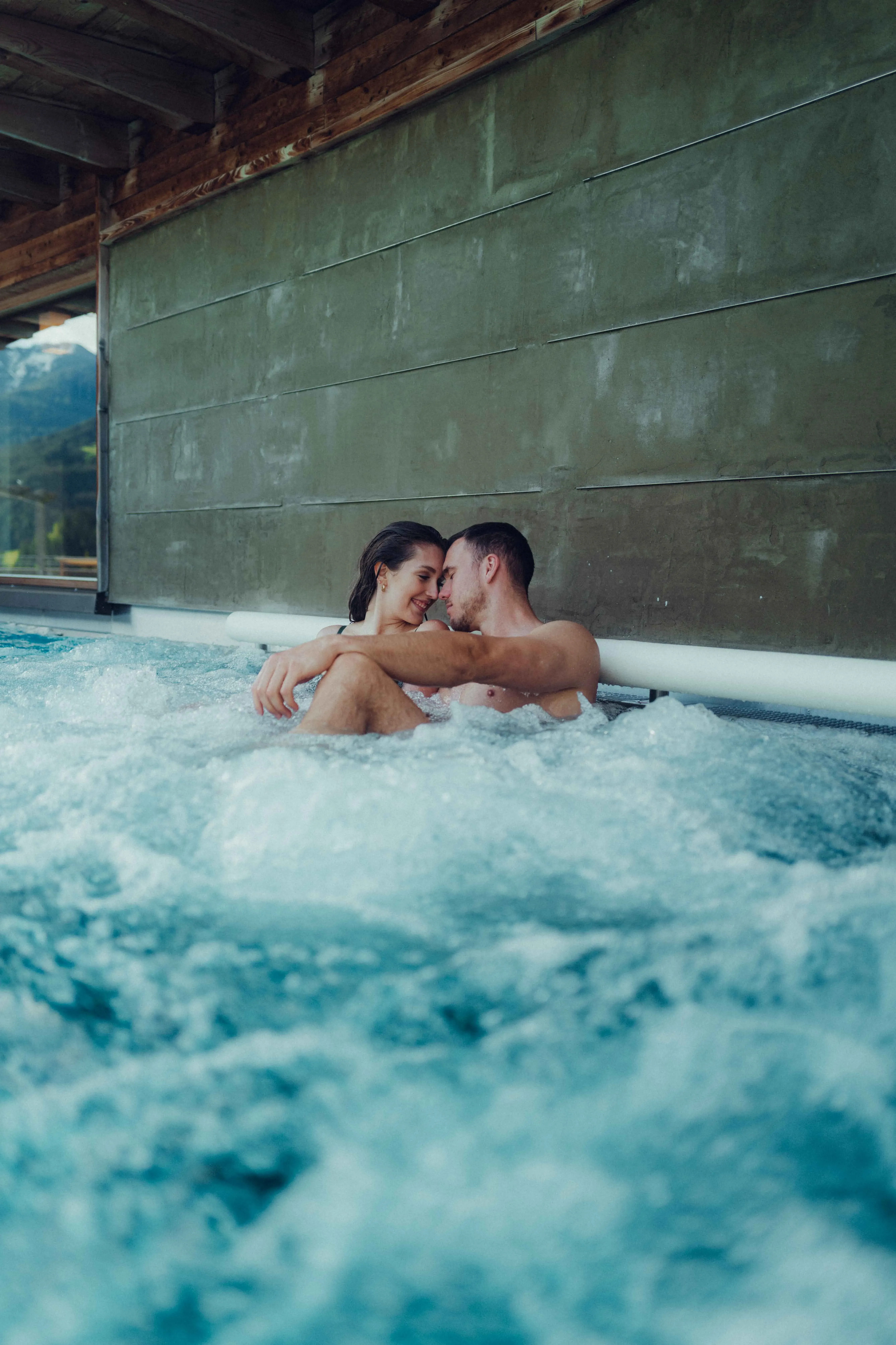 Couple dans la piscine profitant des bulles et de la vue.